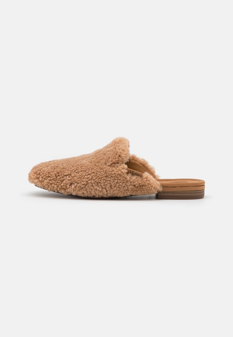 Fuzzy bruin sheepskin instapsloffen met een open achterkant en een platte bruine zool. De textuur is zacht, met een ronde vorm en minimale details.