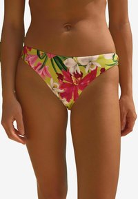 Blommig bikinibyxa med gul bas och rosa och vita blommor, låg midja och slät tyg för bekväm användning.