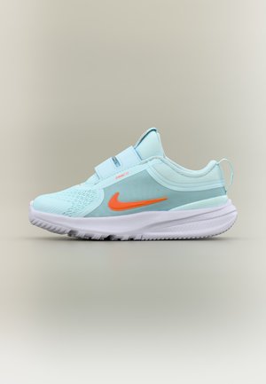 Zapatilla deportiva azul claro con logo naranja de Nike, suela blanca, parte superior de malla y dos tiras ajustables sobre fondo neutro.