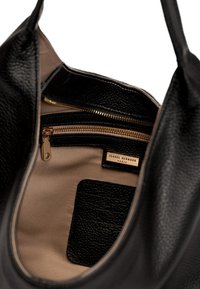 Schwarze Ledertasche mit strukturiertem Äußeren, beigem Innenfutter, goldfarbenem Reißverschluss und einem Markenlabel. Enthält eine Reißverschlusstasche und einen Kartensteckplatz.