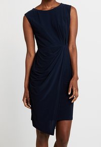 Mörkblå ärmlös klänning med rund halsringning och draperad frontdetalj, med en figursydd silhuett och mjuk tygstruktur.