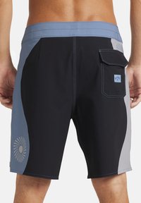 Črni in sivi kopalniške hlače s svetlo modrim pasom in stranskimi paneli, z natisnjenim vzorcem na levi nogi in zadnjim žepom.