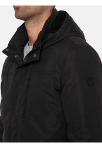 Czarna, hoodie z zamkiem błyskawicznym, napami, kieszenią z przodu oraz teksturowanym materiałem. Posiada naszywkę z logo na lewym rękawie.