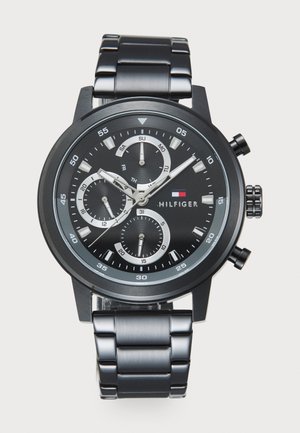 Montre en acier inoxydable noir avec trois sous-compteurs, accents argentés et un cadran noir. Présente une finition brossée et une couronne proéminente sur le côté.