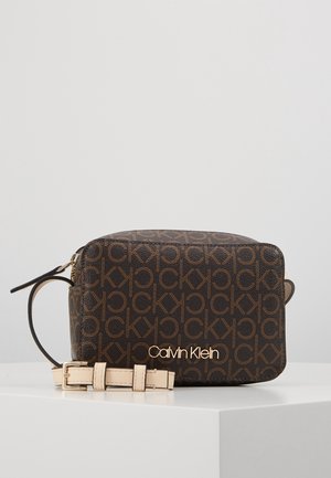 Kabelka přes rameno Calvin Klein z tmavě hnědé embosované kůže s opakujícím se vzorem loga a světle zbarveným nastavitelným popruhem.