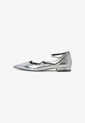 Zapato plano plateado con puntera puntiaguda, correa en el tobillo y detalle decorativo con cadena, tacón bajo y acabado metálico suave.