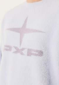 Felpa fuzzy blu chiaro con una texture morbida e un logo a stelle di colore viola chiaro con la scritta "PXP" sul davanti.