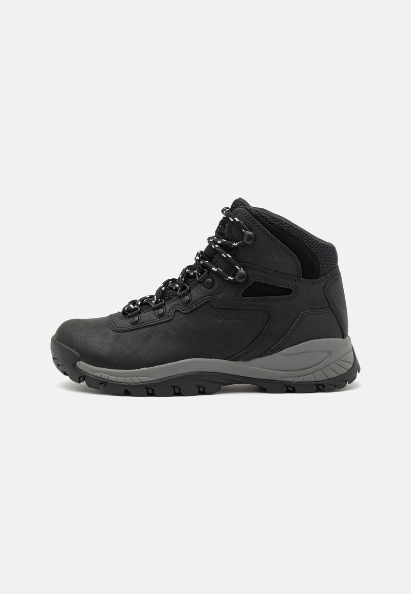 Bota de caminhada preta com design de cano médio, apresentando um upper texturizado, detalhes cinzentos e sola de borracha durável com cravos de tração.