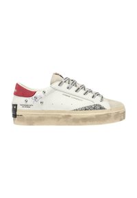 Sneaker bianco con accenti beige e glitter, hardware nero e lacci con logo. Presenta un look usurato e una linguetta sul tallone rossa.