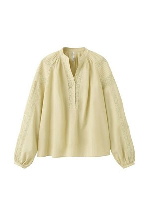 Hellbeige Bluse mit langen Ärmeln, Spitzenverzierungen an Ärmeln und Ausschnitt, drei Knöpfen am vorderen Blendenbereich und geknöpften Manschetten.