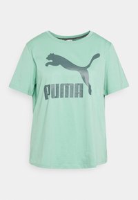 Mintgrön t-shirt med kort ärm och en mörkgrå Puma-logga samt en hoppande kattgrafik på framsidan, rundad halsringning och klassisk passform.