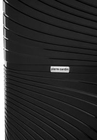 Valigia rigida nera con superficie testurizzata caratterizzata da linee orizzontali. Logo "pierre cardin" argentato su una banda di accento nera.