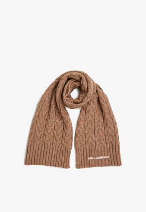 Világosbarna kötött sál, csavart mintával és bordázott végekkel. Az egyik oldalán fehér logó hímzés található. Puha tapintású.