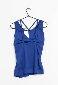 Blå atletisk linne med korsade axelremmar, slät textur och en figurnära design med rundad nederkant. Hänger på en svart krok.