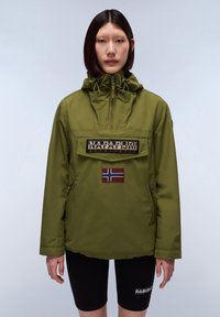Olivgrüner kapuzenpulli mit Reißverschlusskragen, ausgestattet mit einer großen Fronttasche, gesticktem Logo und Norwegen-Flaggen-Patch. Sichtbare schwarze Shorts.