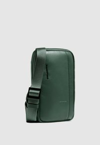 Bolso bandolera de cuero verde con forma rectangular, superficie texturizada, correa ajustable y una elegante abertura con cremallera.