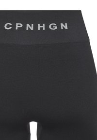 Čierne legíny z elastického materiálu, s širokým pásom so svetlošedým nápisom "CPNHGN" a hladkou textúrou.