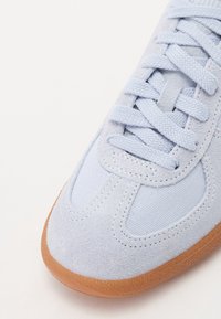 Ljusblå mocka- och mesh-sneakers med platta snören och en sula av gummigummi. Har stickade detaljer och rundad tåsdesign.