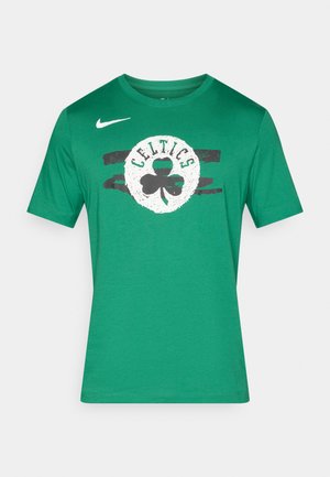 Camiseta de algodón verde con un logo redondo blanco que incluye el texto "CELTICS" y un trébol, acentuado por diseños de pinceladas negras. Logo de Nike en el hombro.