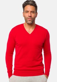 Pull en V rouge avec des manches longues, fabriqué dans un matériau doux ; design ajusté avec des poignets et un ourlet côtelés, texture lisse.