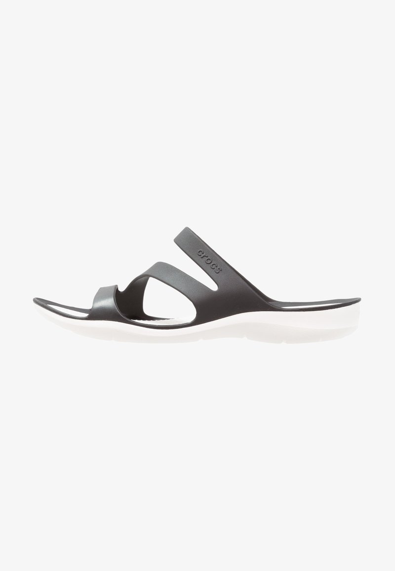 Sandale slide Crocs noire avec deux brides et semelle blanche, vue de côté sur fond blanc.