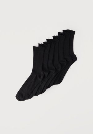 Seven pairs of black mid-calf socks with ruffled edges stacked diagonally on a plain white background.
