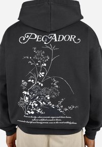 Sort hættebluse med hvide blomster grafik og tekst på ryggen. Blødt stof, afslappet pasform, med en rummelig hætte og ribbede manchetter.