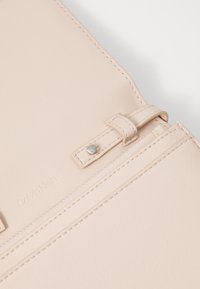 Portafoglio Calvin Klein in morbida pelle rosa, con una texture liscia, cuciture pulite, chiusura a scatto e branding discreto.