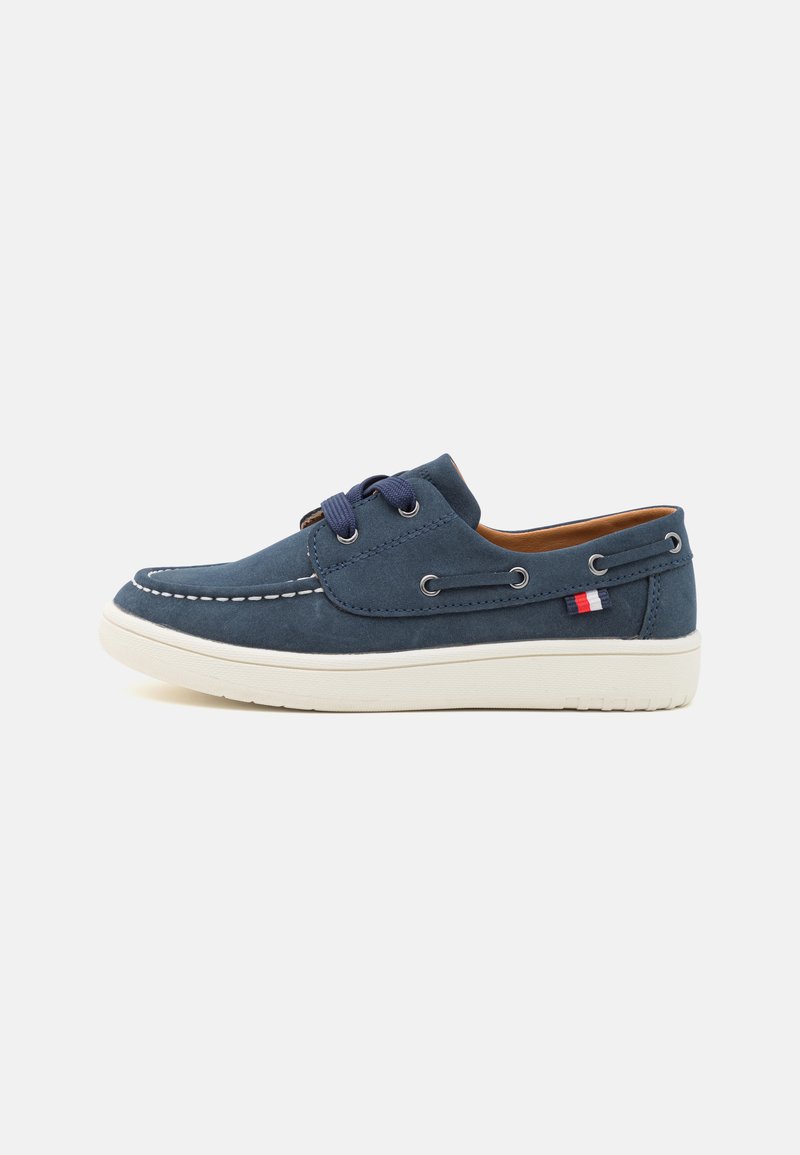 Navy blue suede shoes with white rubber sole. Features lace-up design, stitching accents, and metal eyelets. Small red, white, and blue logo detail.