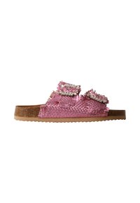 Sandale slide tissée rose avec deux brides effilochées décorées de perles sur une semelle marron à fond texturé.