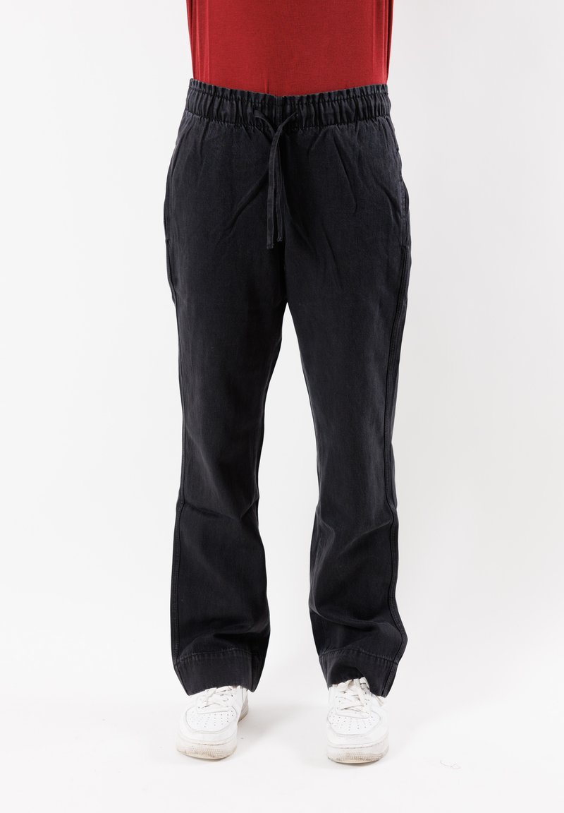Pantaloni in lino neri con elastico in vita, dalla vestibilità comoda e con tasche laterali, caratterizzati da una superficie liscia e da una gamba svasata.