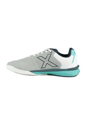 Zapatilla deportiva de corte bajo en gris y blanco con suela turquesa y gran logo X en el lateral, vista desde el lado exterior.