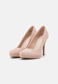 Nude suède hoge hakken met een ronde neus, 10 cm stilettohak en een plateau voor extra hoogte en comfort.