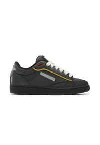 Black leather sneakers with white laces, yellow and teal accents, and a textured black sole. Features a reflective side panel and brand logo.