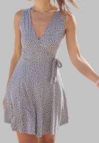 Šaty bez rukávů s V výstřihem v námořnické modři s krémovým abstraktním vzorem, mají přiléhavý pas a rozšířenou sukni s uzlem na boku. Měkká textura látky.