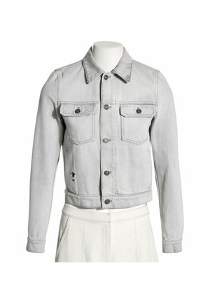 Chaqueta de mezclilla gris claro con botones delanteros, dos bolsillos con solapa en el pecho y mangas largas, mostrada en un torso de maniquí blanco.