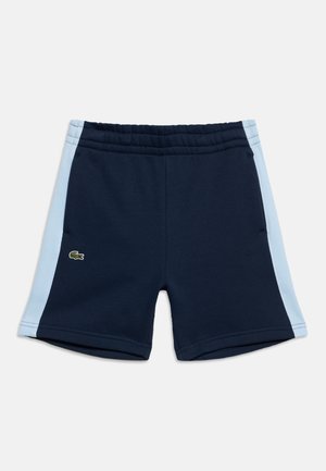 Short de sport bleu marine avec des panneaux latéraux bleu clair et une ceinture élastique, avec un petit logo crocodile vert sur la jambe gauche.