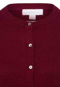 Cardigan en tricot bordeaux avec col rond, fermeture par boutons argentés et rouges, et texture douce. Étiquette de taille « S » visible.