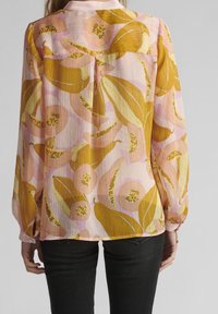 Långärmad blus i lätt, plisserad tyg med ett gult och rosa blommönster, med krage och knappmanschetter.