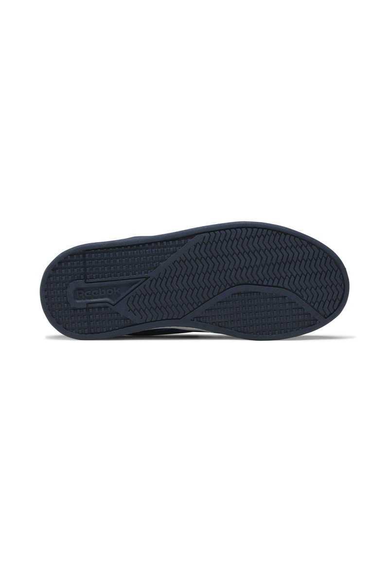 Suela de zapato Reebok que presenta una superficie de goma negra texturizada con un patrón de banda de rodadura ondulado y un logotipo embossado en el lateral para agarre y estabilidad.
