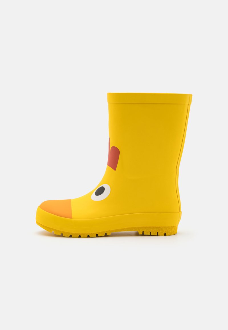 Keltaiset kumisaappaat pyöreällä kärjellä, joissa on sarjakuvamainen kasvosuunnittelu, oranssit yksityiskohdat ja teksturoitu, pitävä pohja.