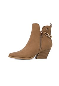 Stivale alla caviglia in faux suede marrone con punta affilata e tacco impilato. Presenta una cerniera laterale e un accento in catena dorata. Texture liscia con finitura opaca.