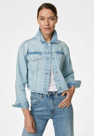 Chaqueta de mezclilla azul claro con un diseño corto, dos bolsillos frontales y botones plateados. Con dobladillo deshilachado y textura ligeramente desgastada.