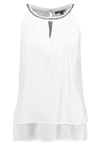 Blouse blanche sans manches avec des plis au niveau du décolleté, une découpe en forme de clé et une bordure argentée au col. Ourlet à deux couches.