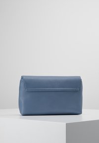 Borsa clutch in pelle blu con finitura testurizzata e grana a ciottoli, dotata di chiusura a patta e design minimalista. Interno foderato liscio.