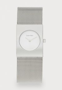 Srebrni ručni sat Calvin Klein s pravokutnim kućištem, mrežnom narukvicom, minimalističkim brojčanikom i bez brojeva, prikazuje vrijeme 10:10.
