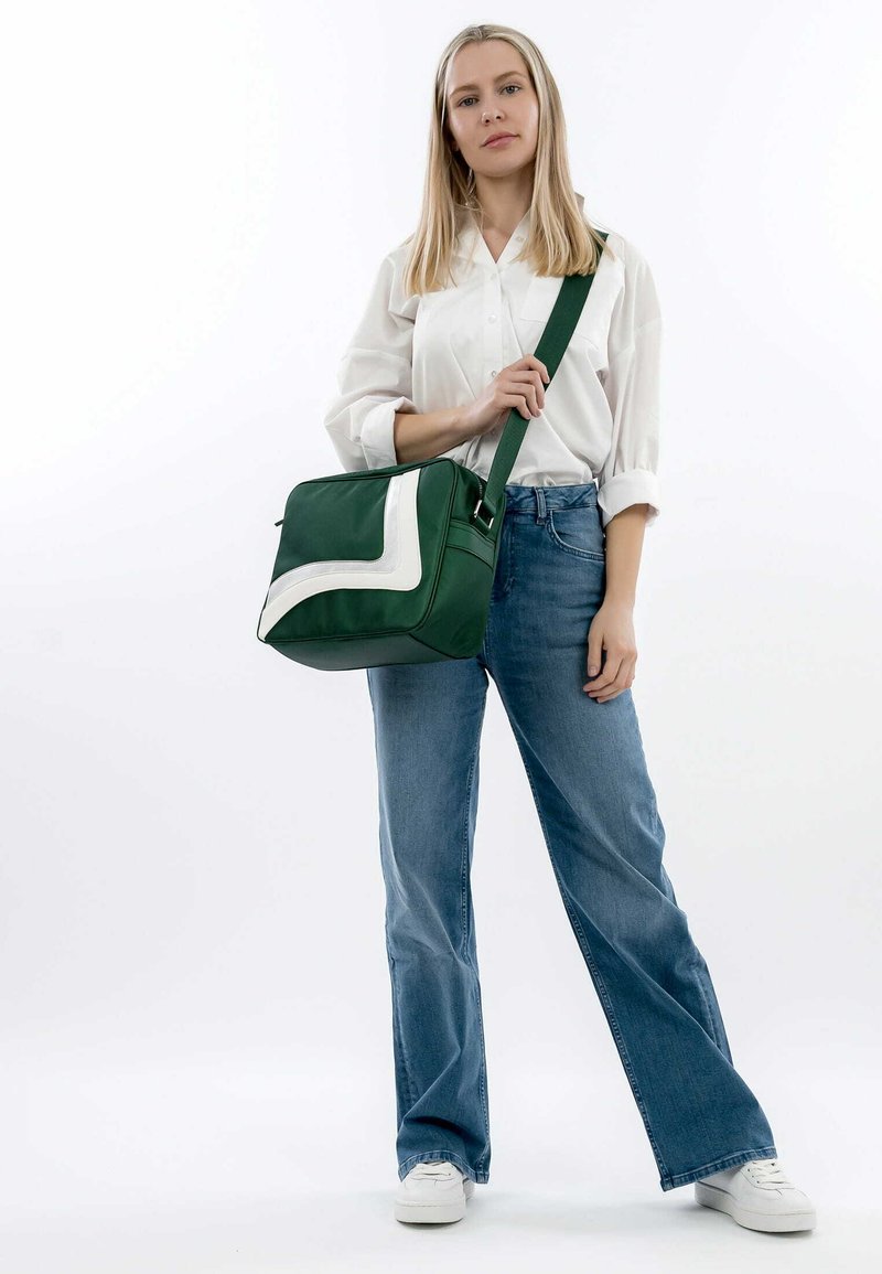 Grøn syntetisk crossbody-taske med en hvid diagonal detalje, firkantet form og justerbar rem. Robust tekstur, kompakt design.