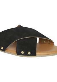 Zwarte suede instap sandaal met kruislingse banden, voorzien van goudkleurige studs en een beige voetbed. Plat ontwerp met open tenen en hielen.