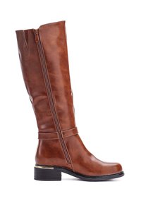 Bota de cuero marrón hasta la rodilla con cremallera lateral, tacón bajo apilado y correa decorativa justo por encima del tobillo, mostrada de perfil sobre fondo blanco.