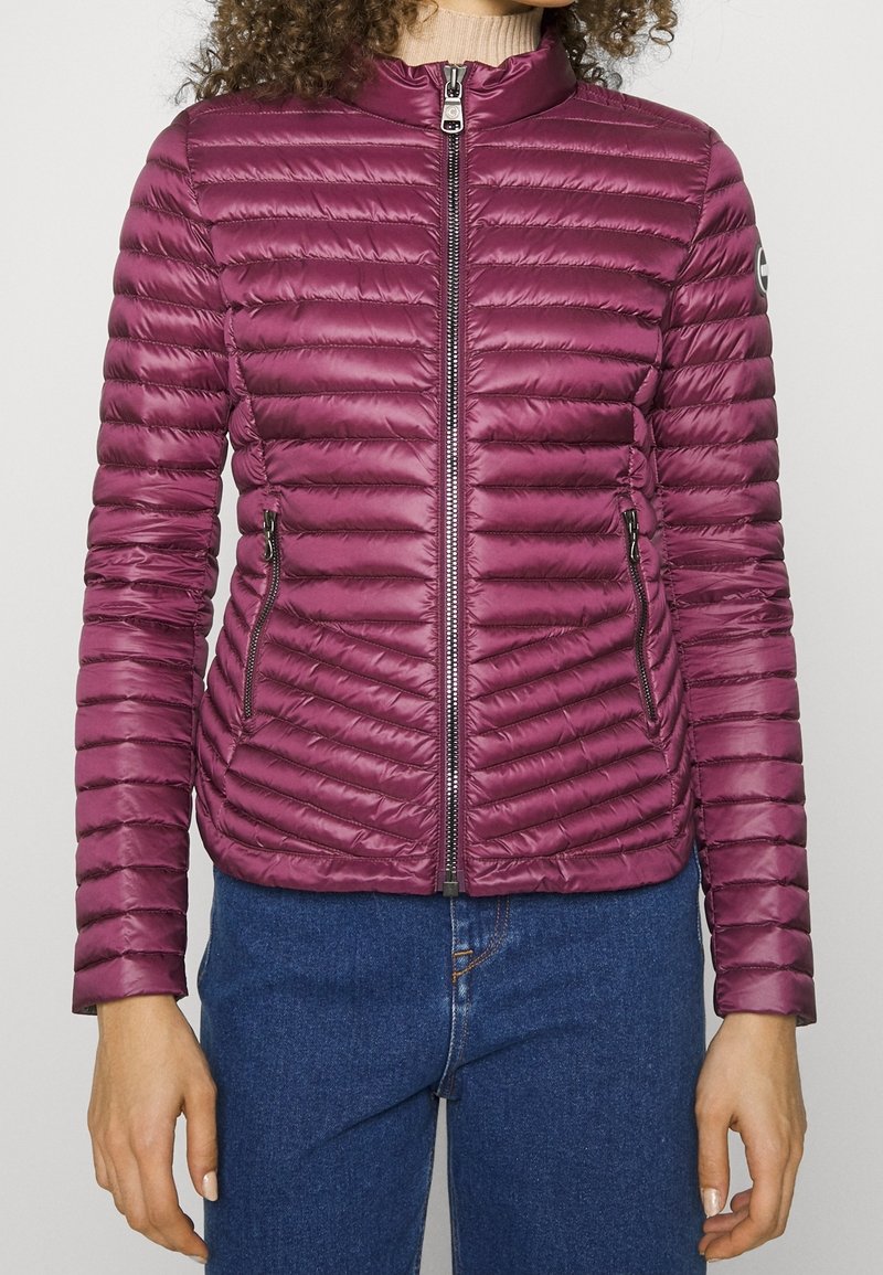 Figurvänlig, vinröd puffjacka med horisontellt quiltat mönster, hög krage, framzip och två zip-fickor på sidorna.